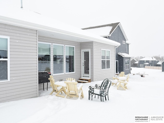 snow covered rear of property featuring entry steps