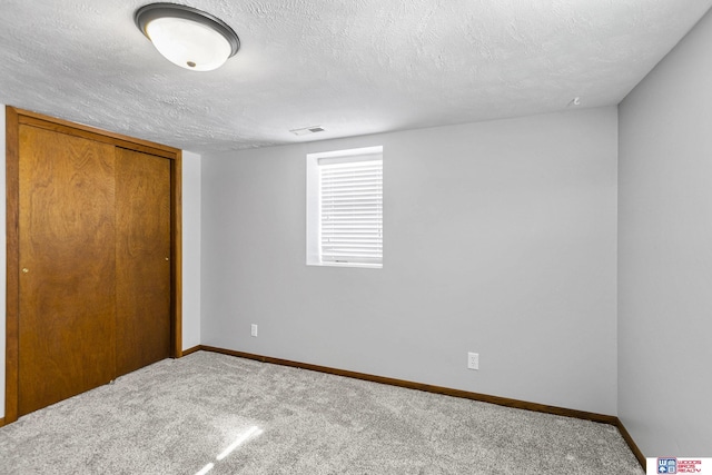 unfurnished bedroom featuring carpet floors, baseboards, visible vents, and a textured ceiling