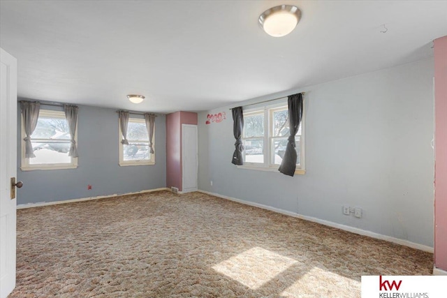 empty room featuring baseboards and light colored carpet