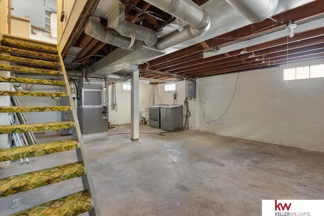 basement with heating unit, plenty of natural light, electric panel, and stairway