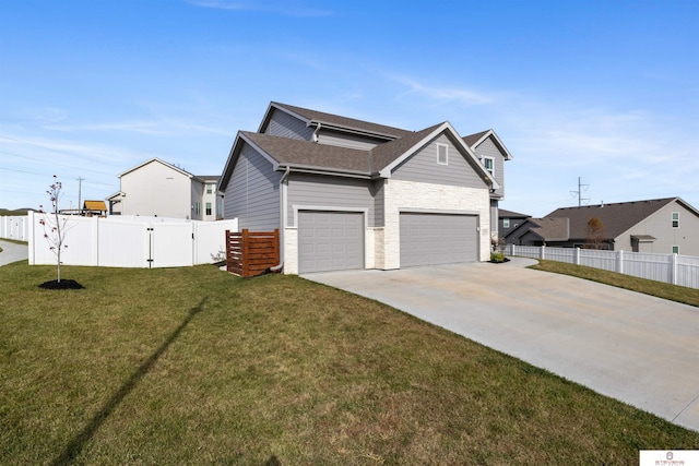 view of side of property featuring a yard, an attached garage, fence, stone siding, and driveway