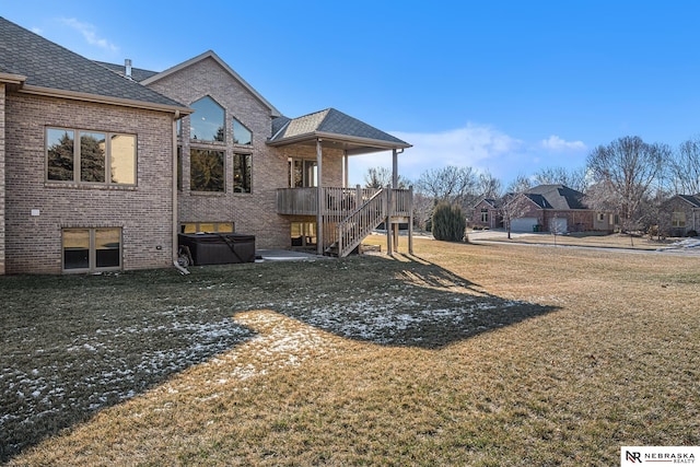 rear view of house featuring stairs, a yard, and brick siding