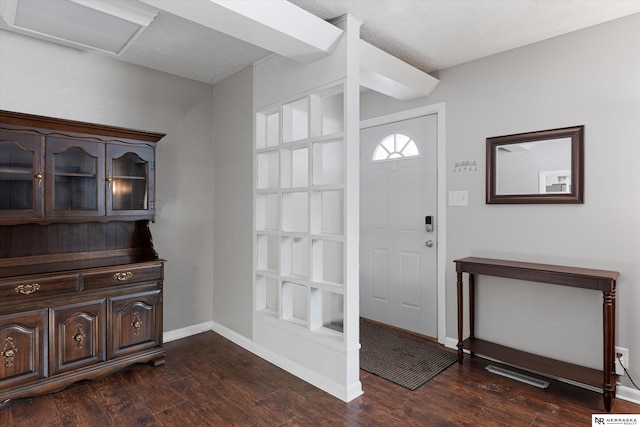 entrance foyer with dark wood-style floors, baseboards, and visible vents