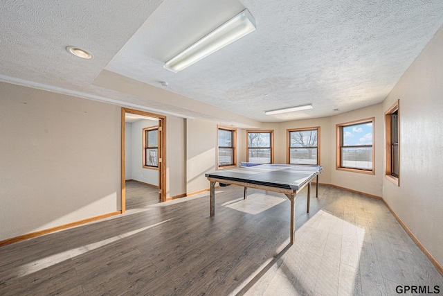 rec room featuring a textured ceiling, baseboards, and wood finished floors