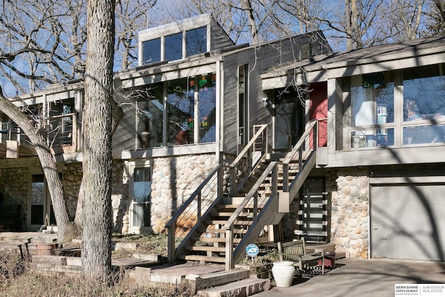 doorway to property with a garage and stone siding