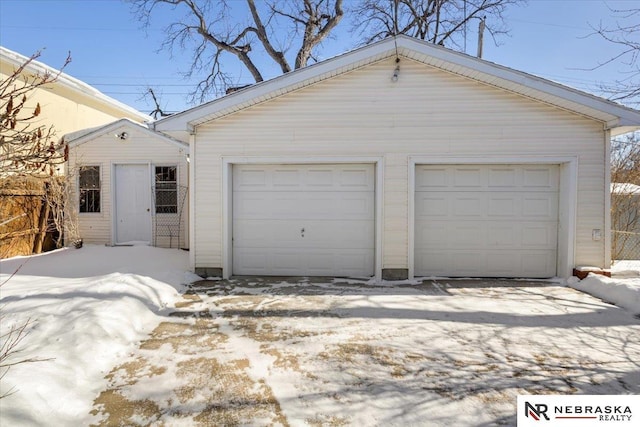 snow covered garage featuring a garage