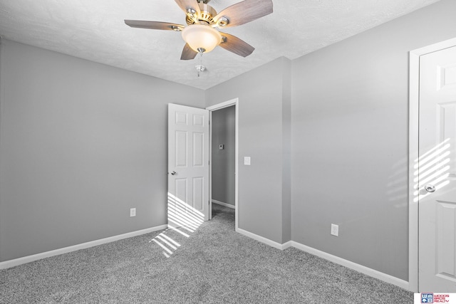 unfurnished bedroom featuring ceiling fan, a textured ceiling, baseboards, and carpet flooring