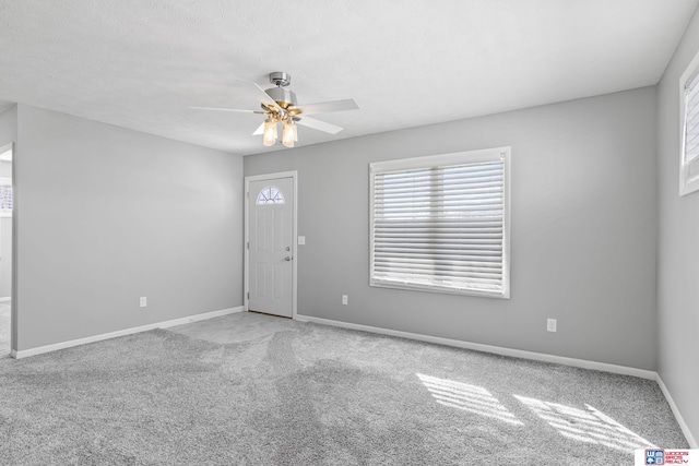 unfurnished room featuring ceiling fan, a textured ceiling, carpet, and baseboards