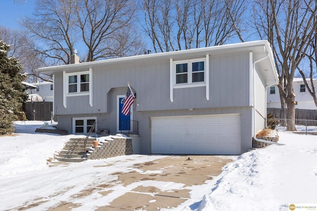 split foyer home with a chimney and fence