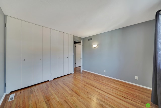 unfurnished bedroom featuring baseboards, visible vents, and light wood-type flooring