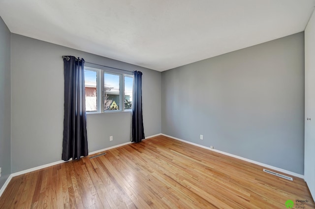 unfurnished room featuring visible vents, baseboards, and light wood finished floors