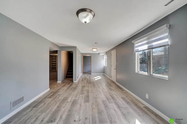 interior space with visible vents, stairway, light wood-type flooring, and baseboards