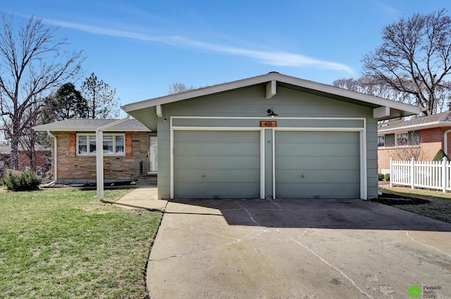 garage featuring driveway and fence