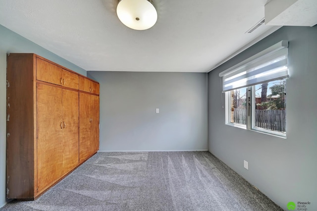 unfurnished bedroom featuring carpet flooring and visible vents