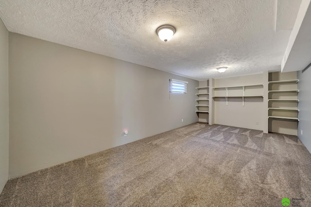 below grade area with carpet flooring and a textured ceiling