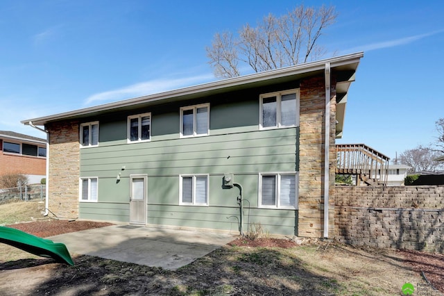 rear view of property featuring stairway, fence, and a patio area