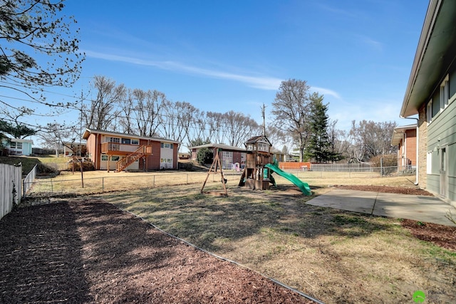 view of yard with stairway, a playground, and a fenced backyard