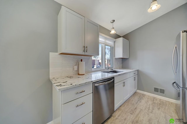 kitchen featuring tasteful backsplash, visible vents, baseboards, appliances with stainless steel finishes, and a sink