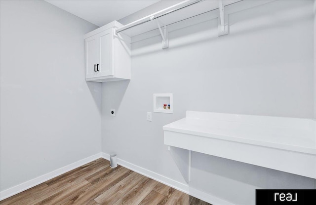 washroom featuring hookup for a washing machine, baseboards, light wood-style floors, cabinet space, and electric dryer hookup