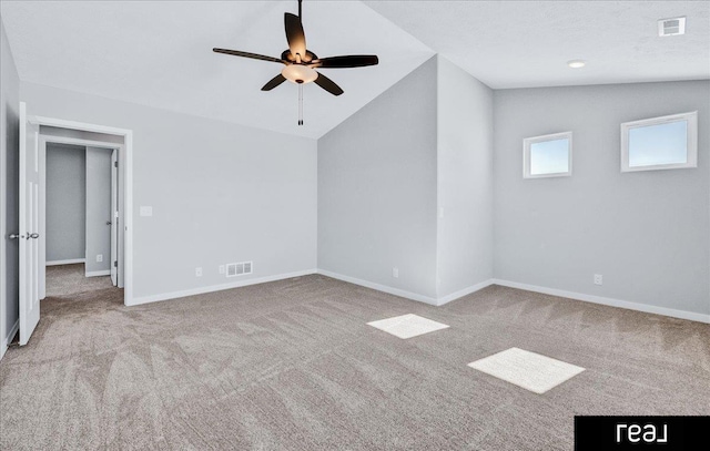 empty room featuring baseboards, visible vents, vaulted ceiling, and light colored carpet