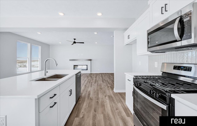 kitchen featuring stainless steel appliances, light countertops, and a sink