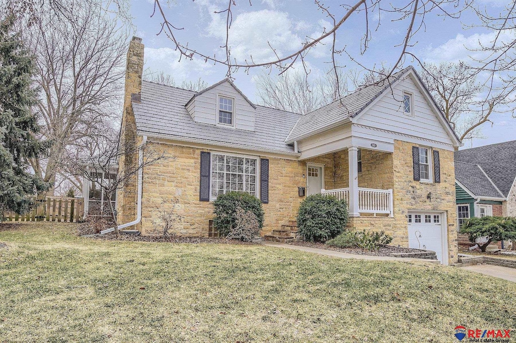 view of front of home with stone siding, a chimney, and a front lawn