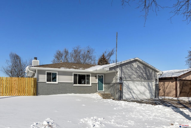 view of front of house featuring a garage, brick siding, a chimney, and fence