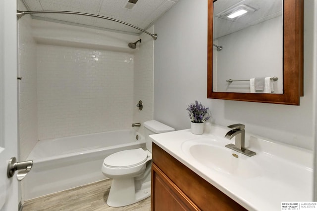 bathroom with toilet, shower / tub combination, wood finished floors, and vanity