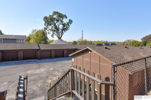 view of yard featuring fence, community garages, and stairs