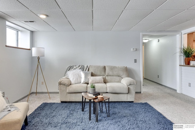 living area featuring baseboards, a paneled ceiling, visible vents, and light colored carpet