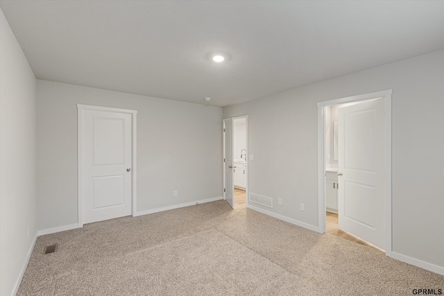 spare room with visible vents, light carpet, and baseboards