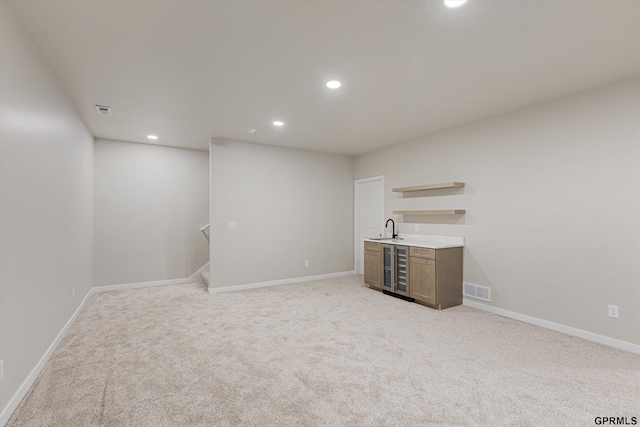 interior space with baseboards, wet bar, visible vents, and recessed lighting