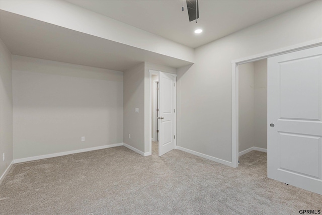 basement featuring light carpet, baseboards, and recessed lighting