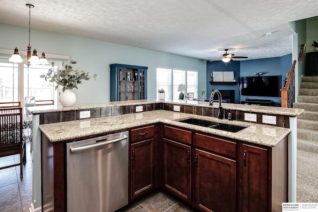 kitchen with dishwasher, open floor plan, a textured ceiling, pendant lighting, and a sink