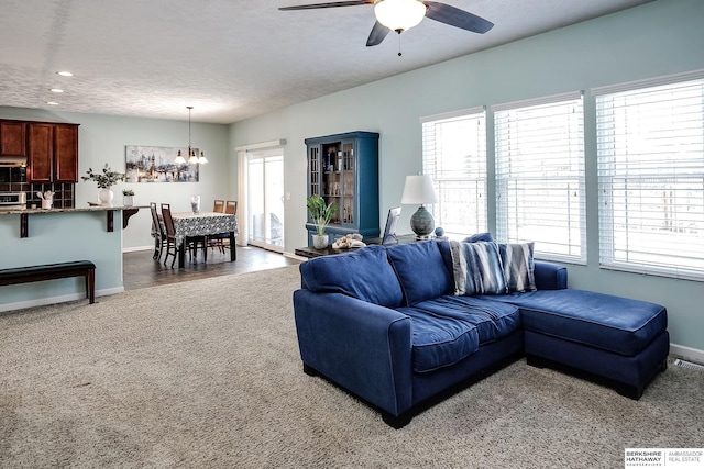 living area featuring plenty of natural light, a textured ceiling, and baseboards