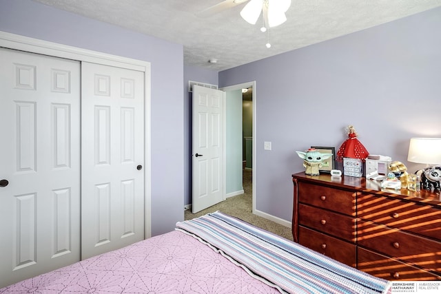 bedroom with a textured ceiling, carpet floors, a ceiling fan, baseboards, and a closet