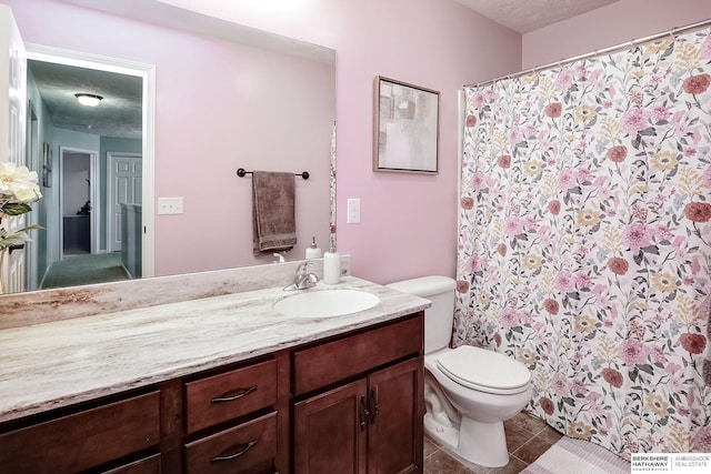 bathroom featuring toilet, a textured ceiling, tile patterned flooring, and vanity