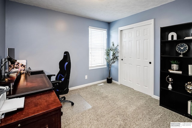 carpeted home office with baseboards and a textured ceiling