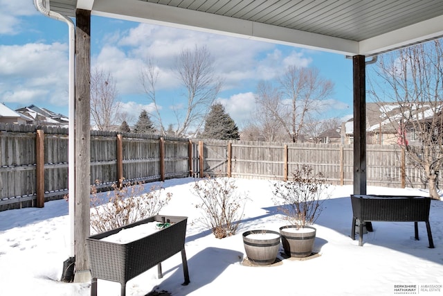 yard covered in snow with a fenced backyard