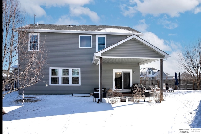 snow covered house with fence