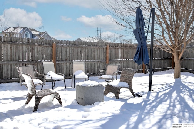 snow covered patio featuring a fenced backyard