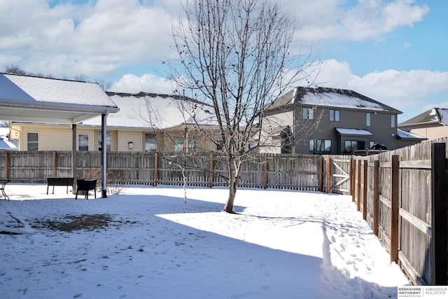 snowy yard with a fenced backyard