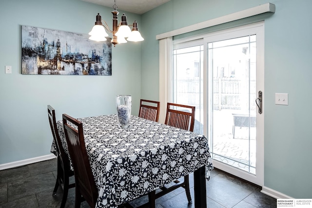 dining area featuring a chandelier, a wealth of natural light, and baseboards