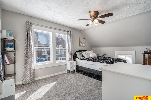 bedroom with carpet floors, multiple windows, vaulted ceiling, and a textured ceiling