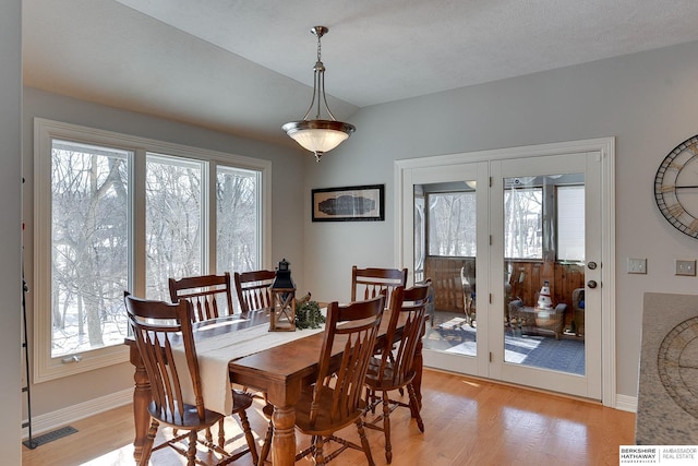 dining area with light wood-style floors, a healthy amount of sunlight, and visible vents