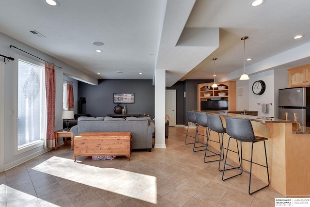 living area featuring recessed lighting, visible vents, and baseboards