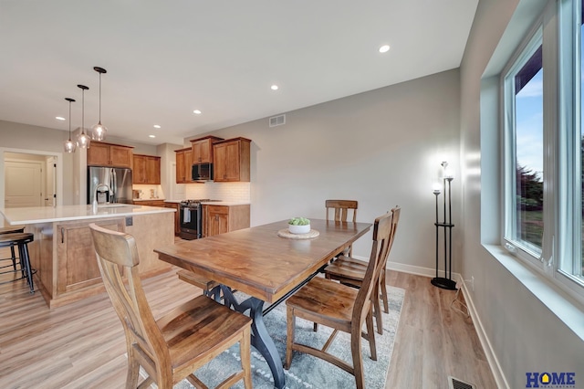 dining room featuring light wood-style flooring, visible vents, baseboards, and recessed lighting