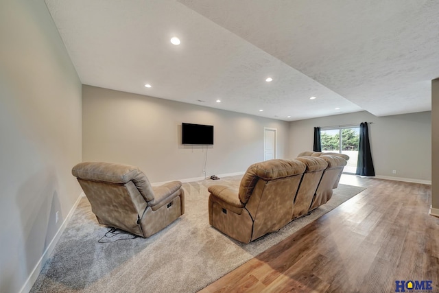 living room with a textured ceiling, recessed lighting, light wood-style flooring, and baseboards