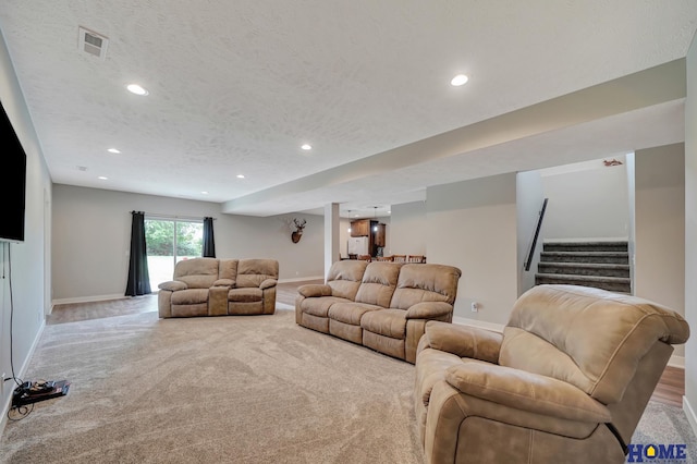 living area with a textured ceiling, stairway, recessed lighting, and baseboards