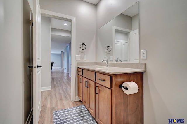 bathroom with vanity, baseboards, and wood finished floors